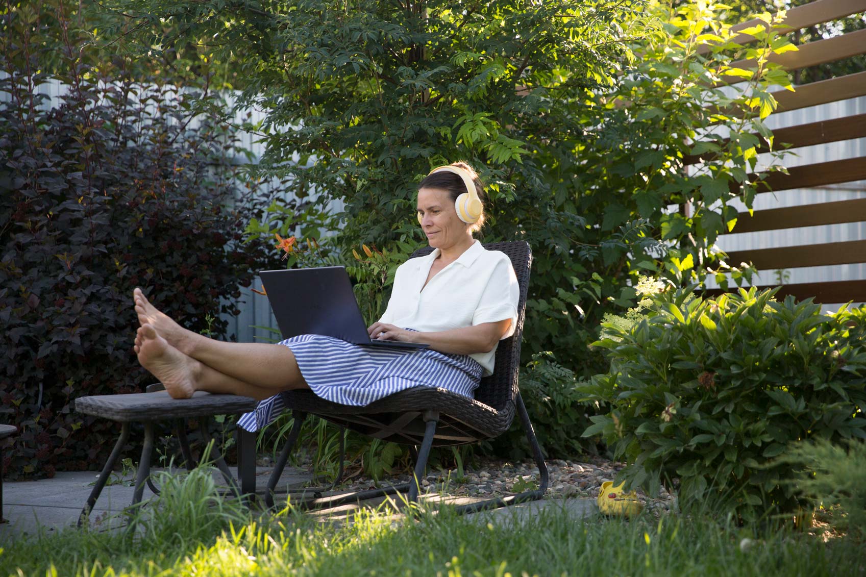 Frau im Garten am Laptop