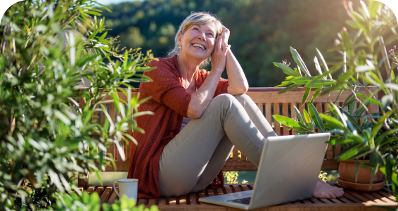 eine Frau mit ihrem Laptop im Garten