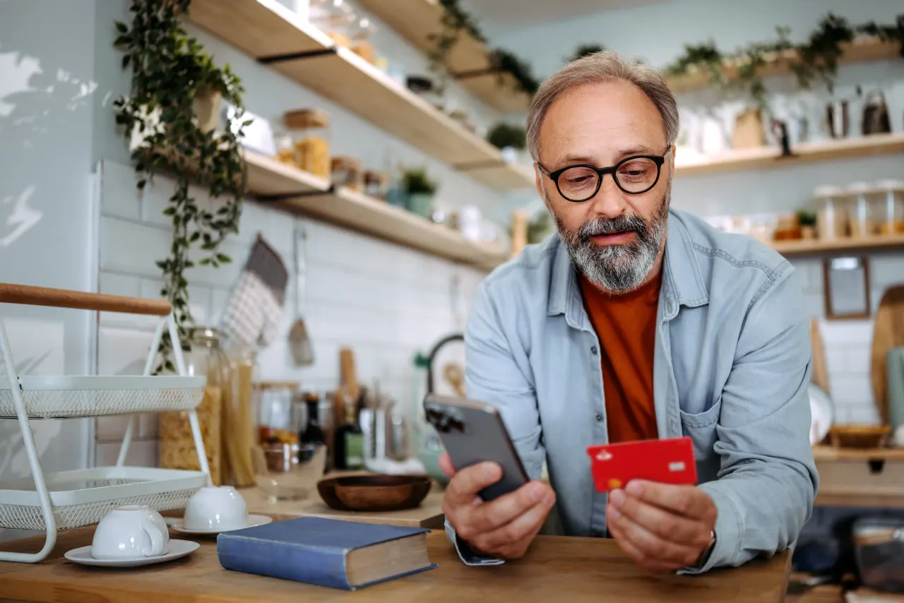 Ein Mann, der über sein Handy einen Kauf tätigt
